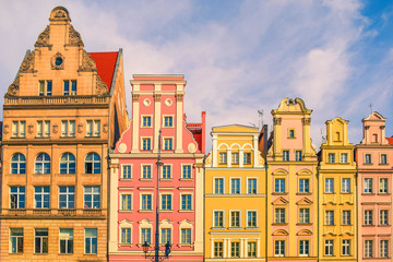 Market square tenements in Europe. Beautiful and colorful facade of historical buildings. Front view with roofs.