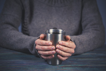 Woman holds a cup of hot tea. Cozy morning at home.