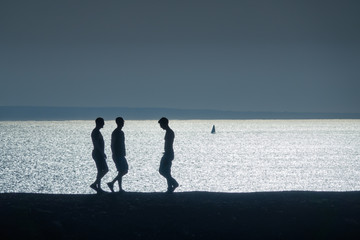 Fototapeta na wymiar silhouette of three people coming together at the beach
