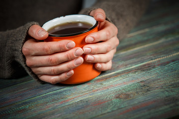 Woman holds a cup of hot tea. Cozy morning at home.