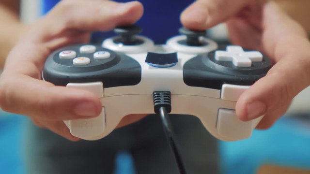 man playing gamepad hands video console on tv. Hand hold new joystick playing video console on tv. Gamer play game with gamepad controller. Gaming man holding simulator joypad. Person with keypad