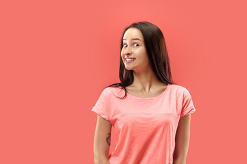 Obraz premium Wow. Beautiful female half-length front portrait isolated on coral studio backgroud. Young emotional surprised woman standing with open mouth. Human emotions, facial expression concept. Trendy colors