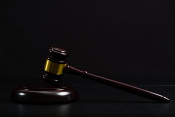 Law or auction gavel on a wooden office desk.