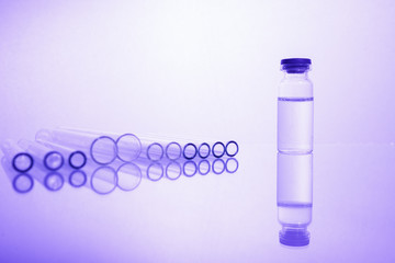 Group of vials with medication on blue methacrylate table.