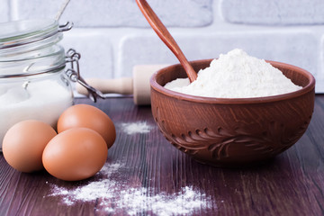 Products and objects for baking chocolate cake on dark wooden table. Concept of home baking.