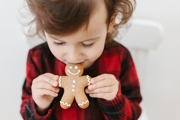 Little girl holding homemade gingerbread cookies