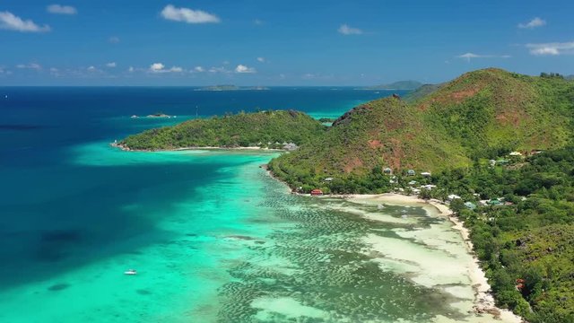 Aerial view of tropical paradise beach with white sand and turquoise crystal clear waters of Indian Ocean - Anse Possession, Praslin Island, Seychelles