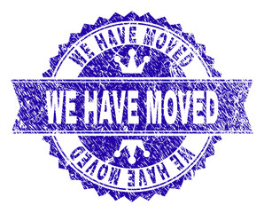 Obraz premium WE HAVE MOVED rosette stamp seal watermark with grunge texture. Designed with round rosette, ribbon and small crowns. Blue vector rubber watermark of WE HAVE MOVED label with grunge texture.