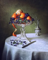 Still life with oranges and viola flowers
