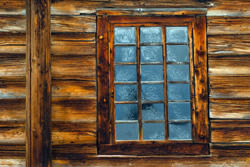 window in the log wall of an old building
