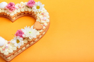 Valentine's Day heart-shaped cake with flowers as decoration. The concept of a gift to a loved one on a holiday.