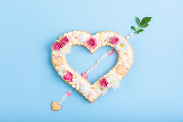 Valentine's Day heart-shaped cake with flowers as decoration. The concept of a gift to a loved one on a holiday.