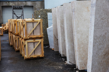 Side view of the edge of the granite slab in bulk. A stack of granite slabs - marble factory. Background of marble slabs. Natural stone. Background of granite slabs. Granite slabs ready for sale