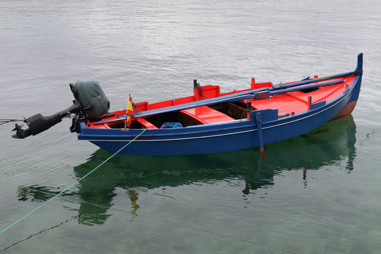 blue fishing wooden boat moored in the sea
