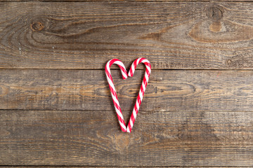 candy canes in heart shape on wooden background - Powered by Adobe