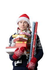 Photo of pensive man in Santa's cap with boxes with gifts, wrapping paper in hands