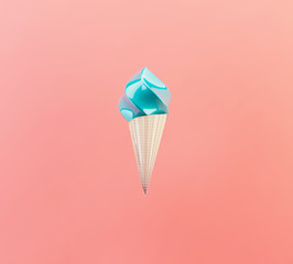 Blue ice cream waffle cone on living coral background. Minimalist creative concept.