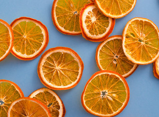 Fototapeta na wymiar Dried slices oranges citrus fruit on light blue background. Homemade natural aroma decor. Concept of holiday. Marry Christmas. Close up, flat lay, top view