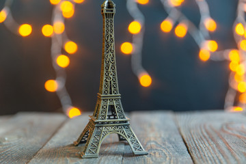 figurine of the Eiffel tower on a background garlands