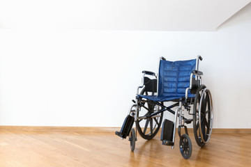 Empty wheelchair in a white room.