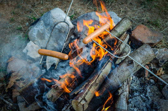 Roasting Hotdogs Over Campfire. Fun And Relaxation Of Preparing Food And Camping Outdoors. Relax And Recreation In Natures Beautiful Outdoor Setting.