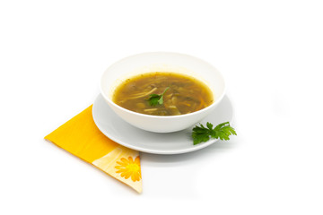 A delicious soup dish with pasta and vegetables, decorated with parsley, over a orange napkin and with a large and clean white background