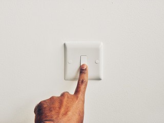 hand with switch on wall
