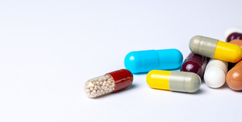 Colored pills in capsules on a gray background