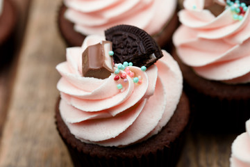 Chocolate, tasty and sweet cupcake with vanilla cream and condensed milk inside, painted in the...