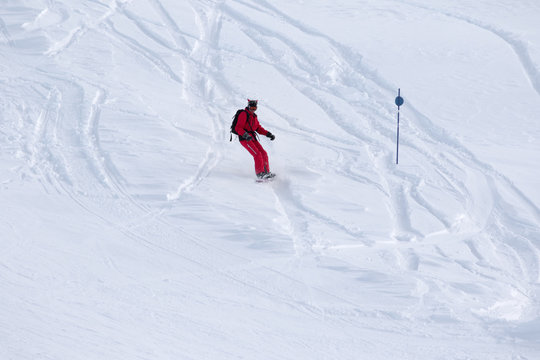 Snowboarder downhill on snowy off-piste slope
