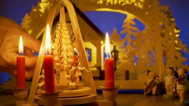 Eine Kerze am 4. Advent wird angez&uuml;ndet