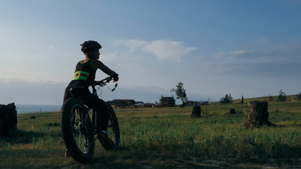 Obraz premium Fat bike also called fatbike or fat-tire bike in summer riding in the forest. Beautiful girl and her bicycle in the forest. She poses and smiles to the operator. Very positive and provocative.