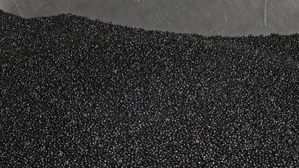 Plastic black gray granulated crumb. Manufacture of plastic water pipes of the factory. Process of...