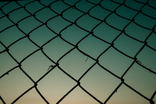 Old metal mesh against the evening sky. Abstract background