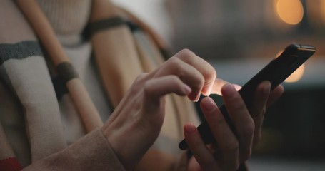 Close up of the smartphone in hands of the Caucasian woman and she tapping or texting on it. Outside. - Powered by Adobe