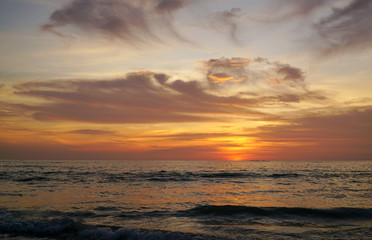 Fototapeta premium Colorful ocean beach sunset with a few clouds