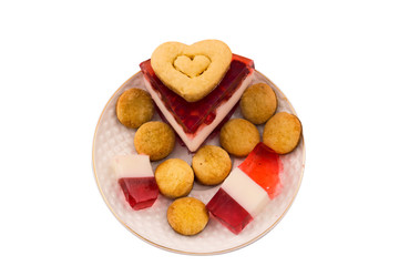 Culinary decoration for Valentine's Day. Gelatin with pomegranate. Heart shaped cookies. Isolated on white background.