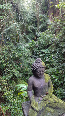 An ancient statue in a forest.