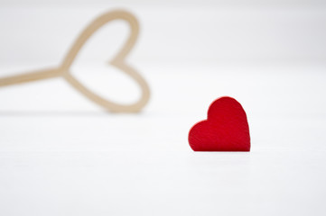 Red heart on white wooden background. In the background - a wooden hollow heart. Valentine's day or Love concept.