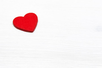 Obraz na płótnie Canvas Decorative red wooden heart on white wooden background. Valentine's day or Love concept.