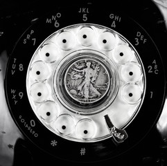 Vintage rotary dial phone with old silver coin