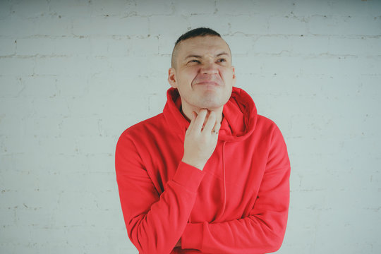 Handsome Guy Posing By A Brick Wall. Crazy Man In A Red Hoodie