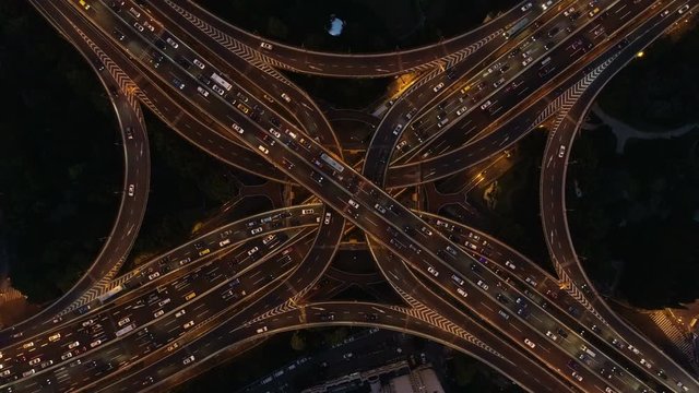 Overhead drone shot of busy intersection in Shanghai at night, rush hour traffic in urban China