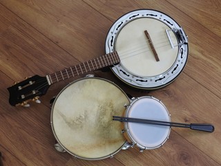 Fototapeta premium Three Brazilian musical instruments: samba banjo, pandeiro (tambourine) and tamborim with drumstick on a wooden surface. They are widely used to accompany samba, the most famous Brazilian rhythm.
