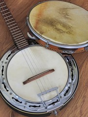 Close-up of two Brazilian musical instruments: samba banjo (strings) and pandeiro (tambourine) on a wooden surface. They are widely used to accompany samba, the most famous Brazilian rhythm.
