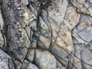 fractured rock strata as a background, cracked rock, stone texture, many cracks in the stone,...