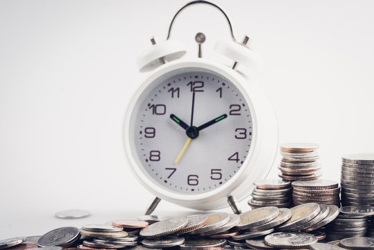 clock and rows of coins for time of finance and business concept