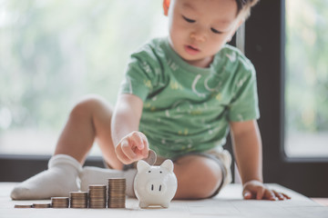baby putting dollar coin in piggy bank,saving concept.