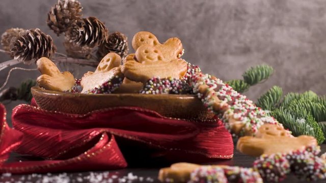 Christmas holiday background with gingerbread cookies, candy canes and evergreens over wooden table. Christmas and New year food. Christmas decoration and sweets on wood background.