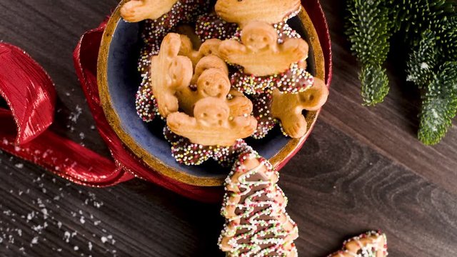 Christmas holiday background with gingerbread cookies, candy canes and evergreens over wooden table. Christmas and New year food. Christmas decoration and sweets on wood background.